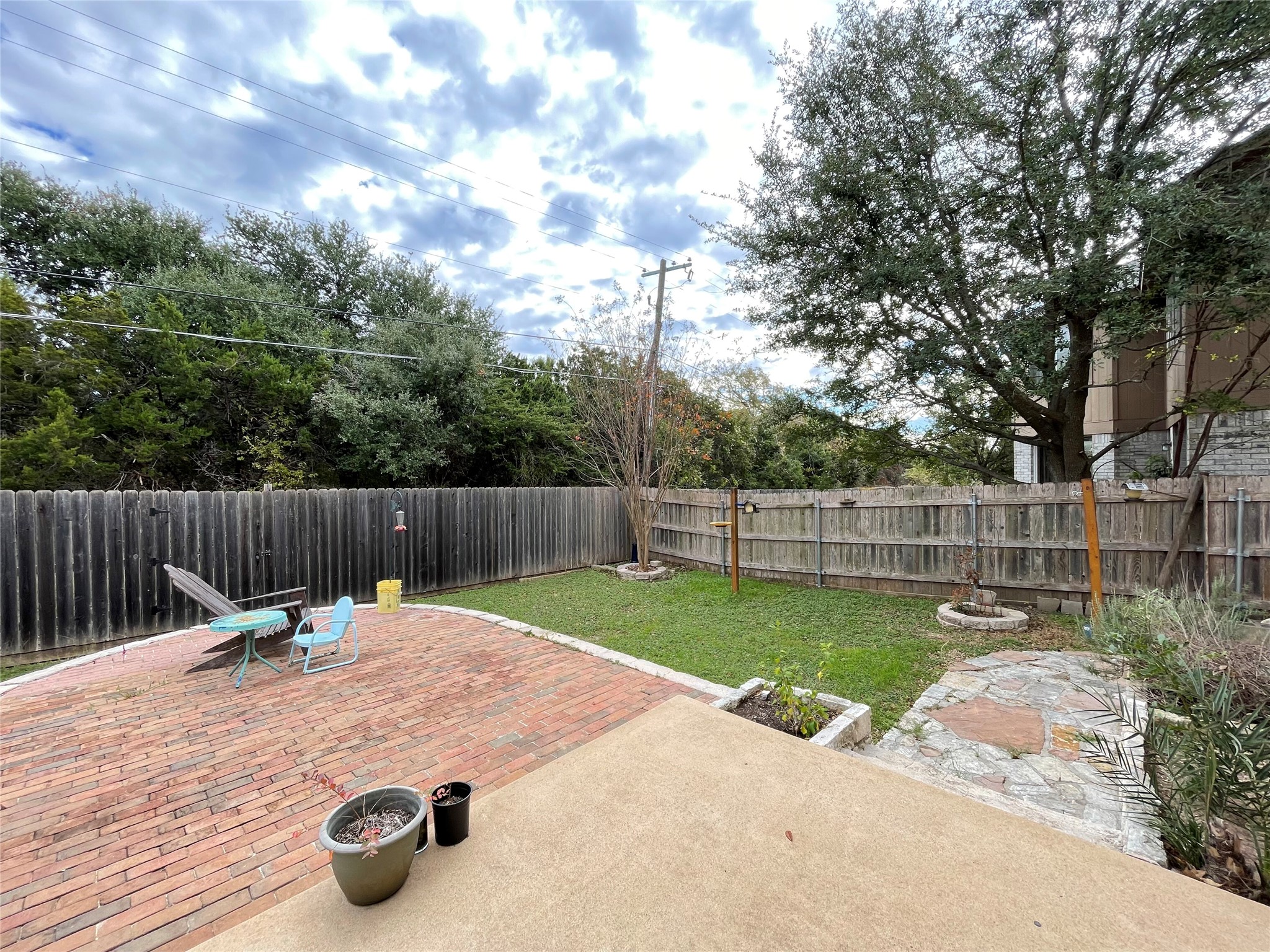 3638 Windhill Loop Round Rock, TX 78681 - Photo 29 of 32 Expansive backyard featuring a brick patio, concrete patio, grass area, and a wood privacy fence