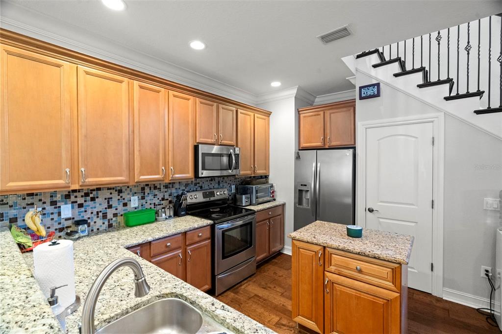 1342 Ribolla Drive Palm Harbor, FL 34683 - Photo 8 of 37 a kitchen with stainless steel appliances granite countertop a sink a stove and a refrigerator