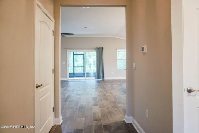 a view of a hallway with wooden cabinets