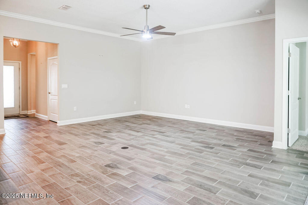 114 Eagles Landing Ln Street St. Augustine, FL 32095 - Photo 7 of 21 an empty room with wooden floor fan and windows