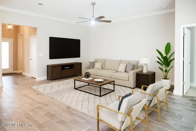 a living room with furniture a flat screen tv and a window
