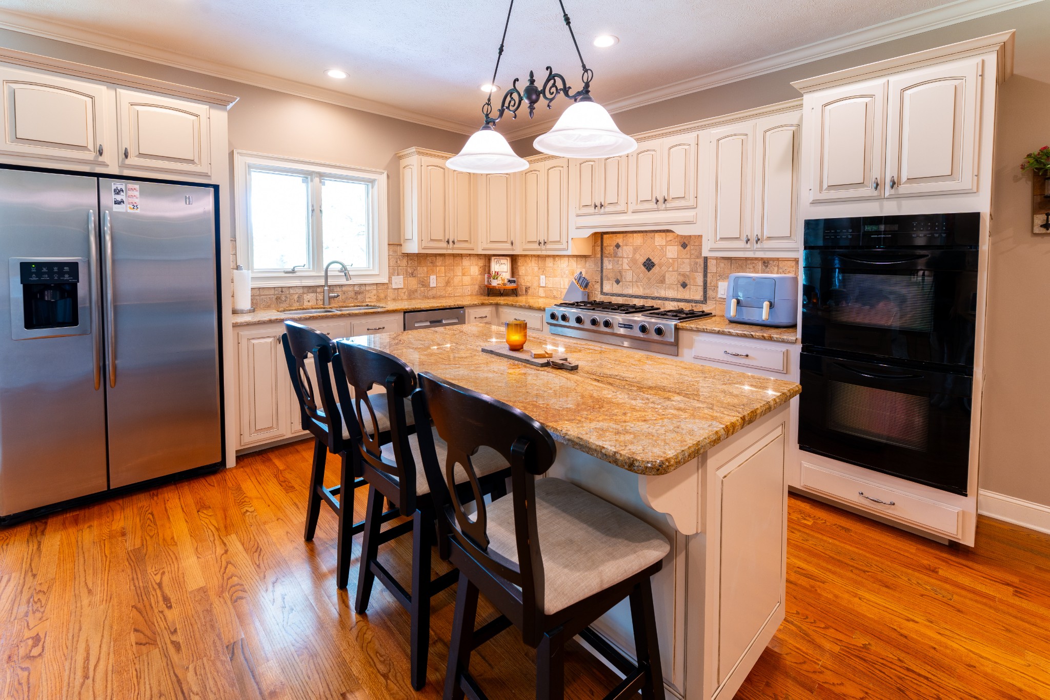 1015 Kelly Road Dyersburg, TN 38024 - Photo 17 of 41 a kitchen with granite countertop a stove a refrigerator and a dining table with wooden floor