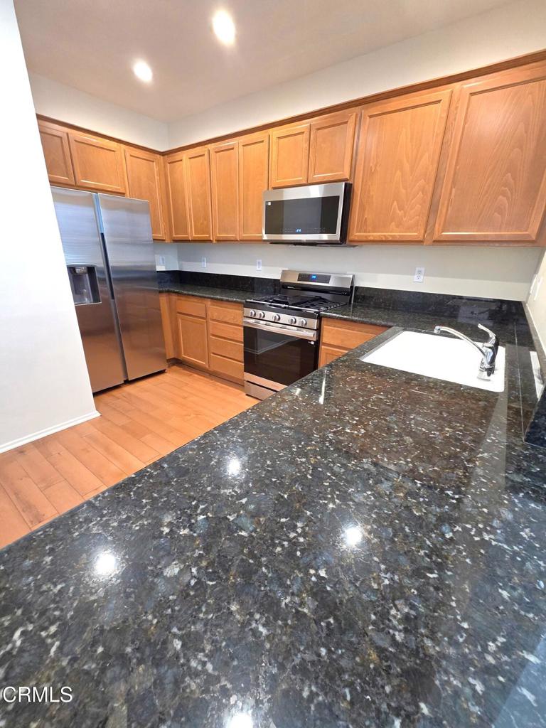 3319 North Ventura Road Oxnard, CA 93036 - Photo 2 of 25 a kitchen with stainless steel appliances a stove a sink and a microwave