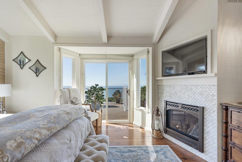 15 Mentone Road Carmel, CA 93923 - Photo 30 of 56 a bedroom with a bed and a fireplace