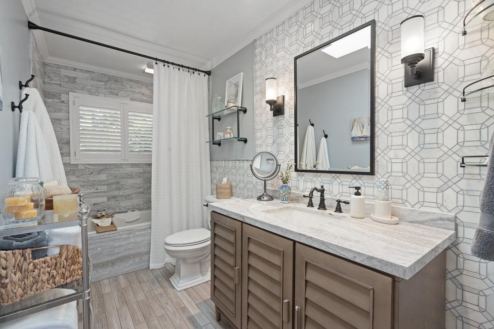 15 Mentone Road Carmel, CA 93923 - Photo 36 of 56 a bathroom with a granite countertop sink a toilet a mirror and shower