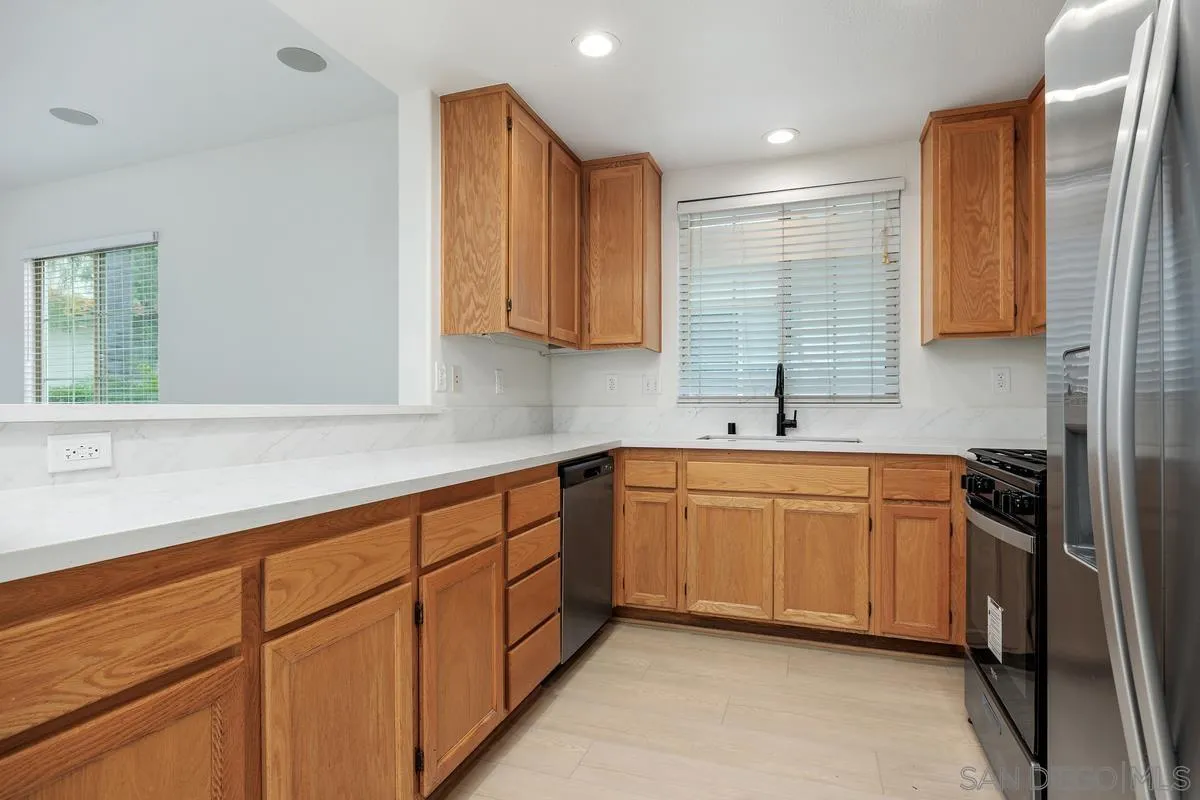 4054 Craven Road, Unit 49 Oceanside, CA 92057 - Photo 11 of 37 a kitchen with stainless steel appliances granite countertop a sink stove and refrigerator