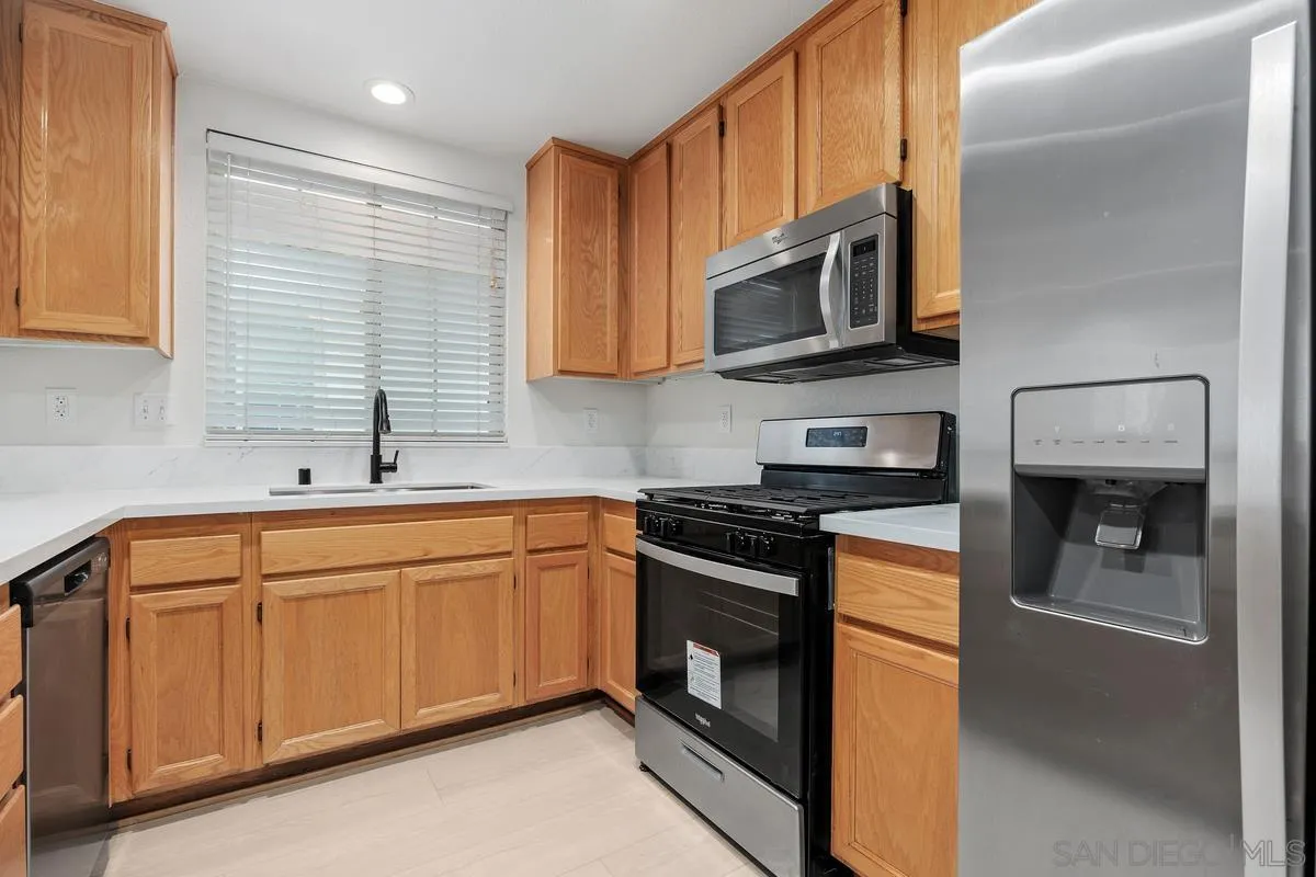 4054 Craven Road, Unit 49 Oceanside, CA 92057 - Photo 12 of 37 a kitchen with stainless steel appliances granite countertop a sink and a stove top oven
