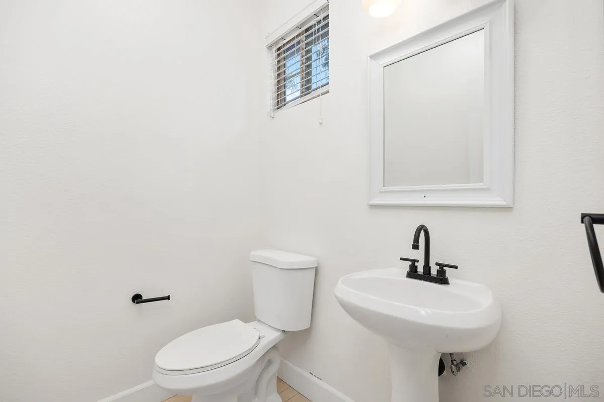 4054 Craven Road, Unit 49 Oceanside, CA 92057 - Photo 20 of 37 a bathroom with a toilet a sink and mirror