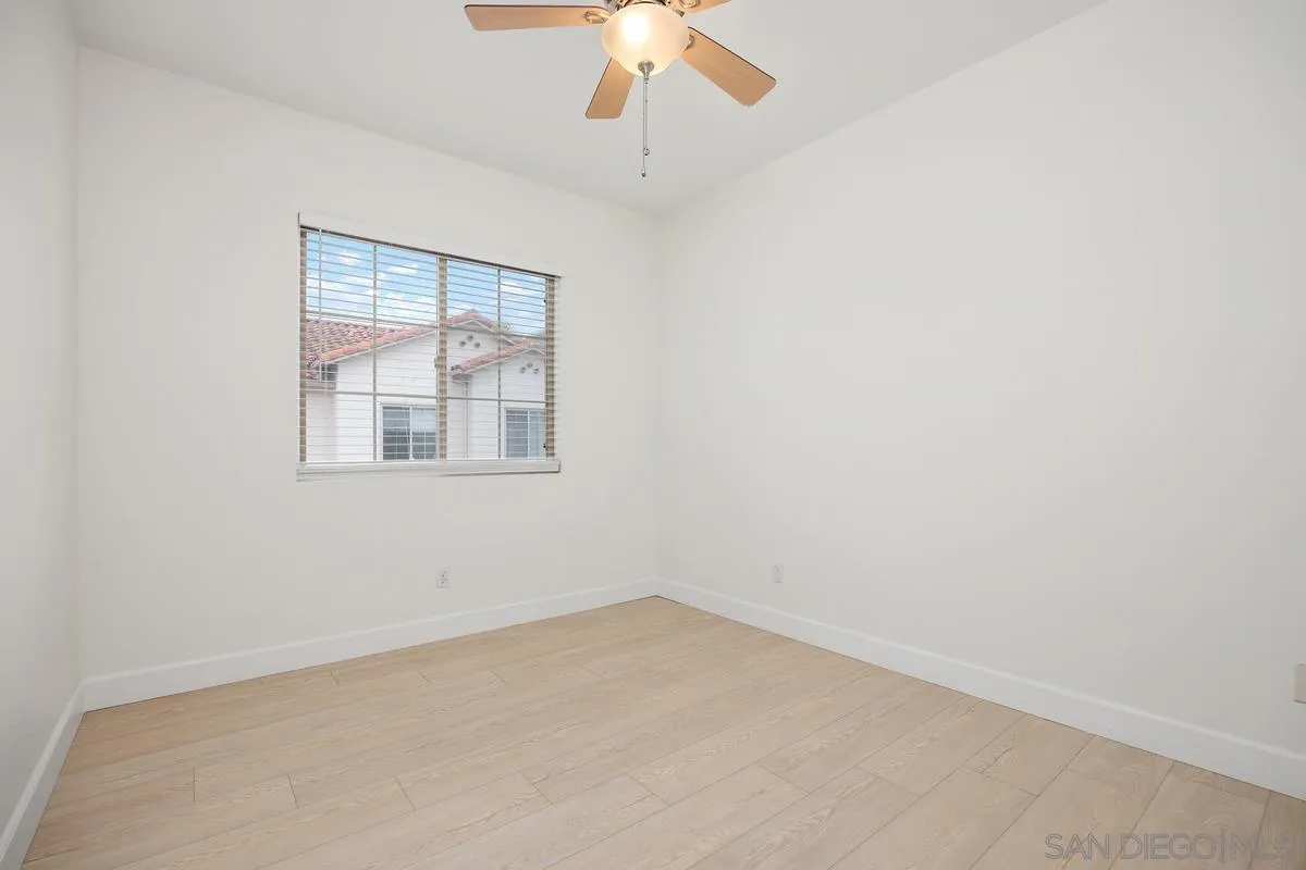 4054 Craven Road, Unit 49 Oceanside, CA 92057 - Photo 26 of 37 an empty room with a chandelier fan and windows