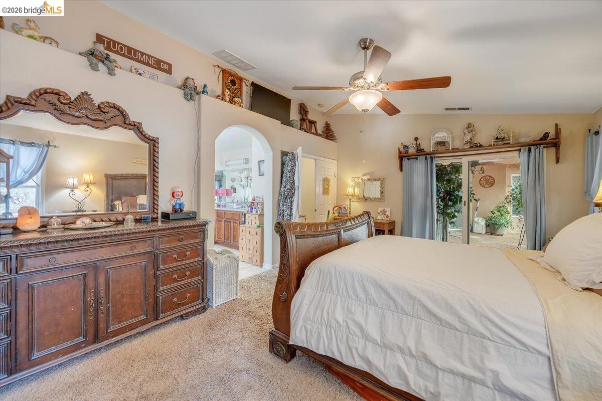 14450 Jacksonville Road Jamestown, CA 95327 - Photo 35 of 85 Carpeted room with a ceiling fan, arched doorway, and sliding glass door