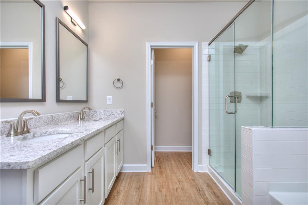 2562 Harbor Ridge Pass, Unit 338 Gainesville, GA 30507 - Photo 18 of 21 a bathroom with a granite countertop sink a mirror and shower