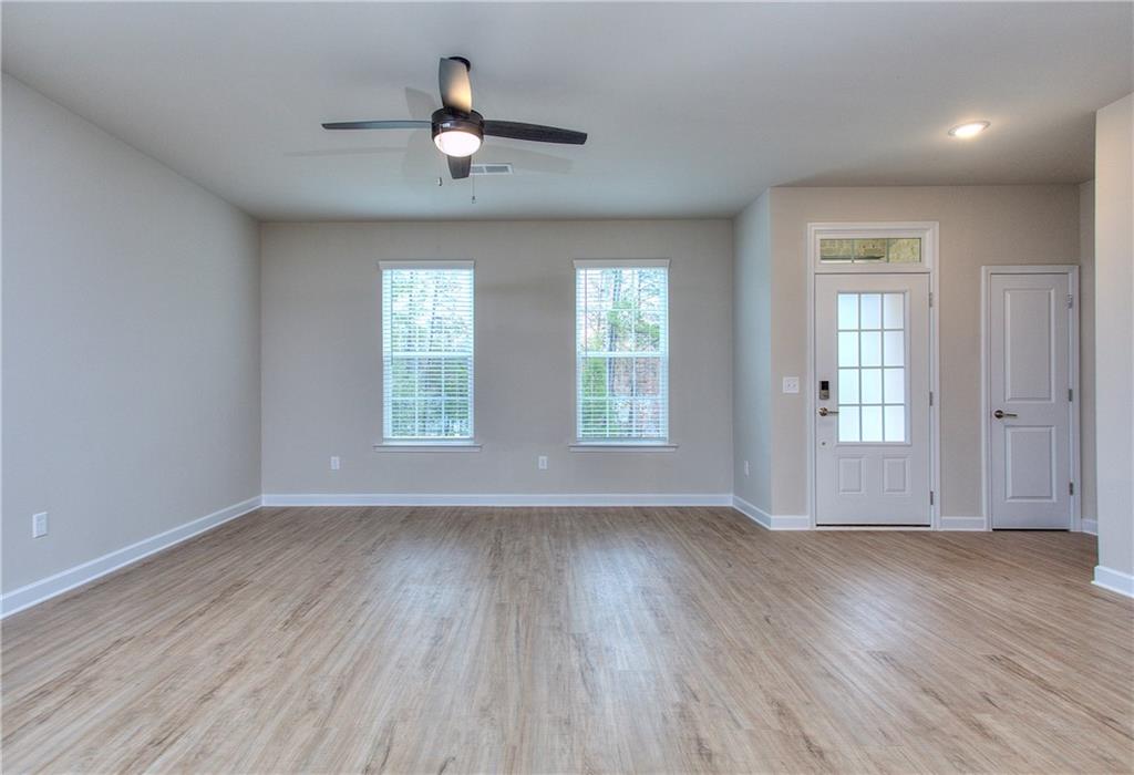 2562 Harbor Ridge Pass, Unit 338 Gainesville, GA 30507 - Photo 3 of 21 an empty room with wooden floor chandelier fan and windows