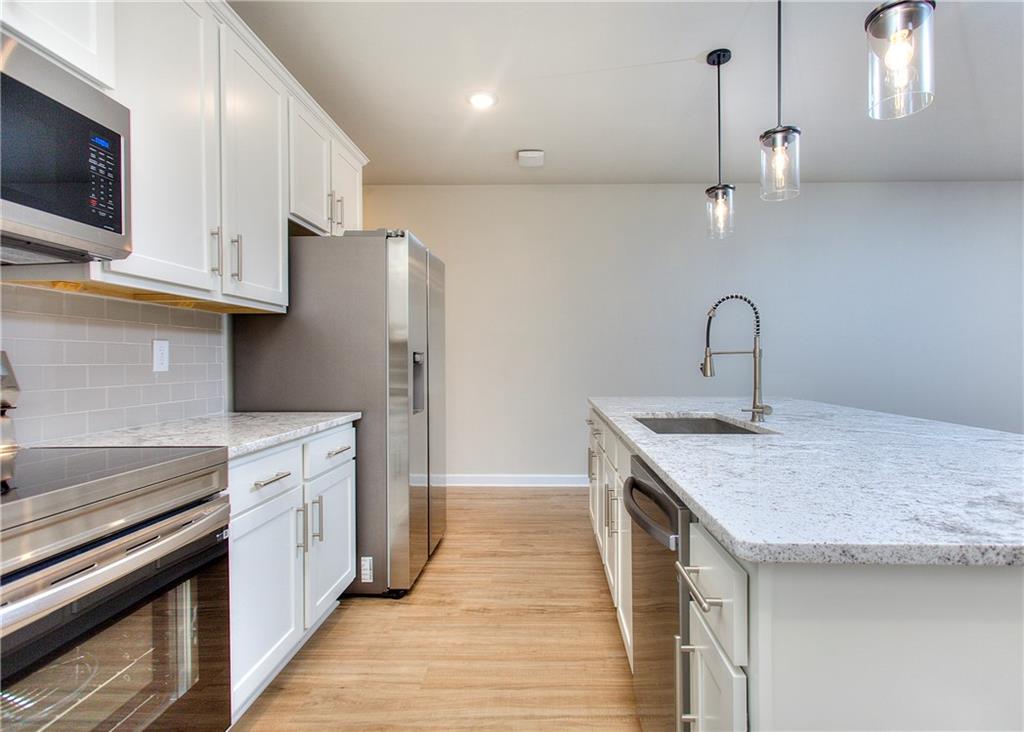 2562 Harbor Ridge Pass, Unit 338 Gainesville, GA 30507 - Photo 9 of 21 a kitchen with stainless steel appliances granite countertop a sink and a stove