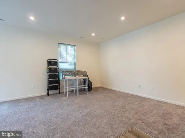 a view of an empty room with furniture and staircase