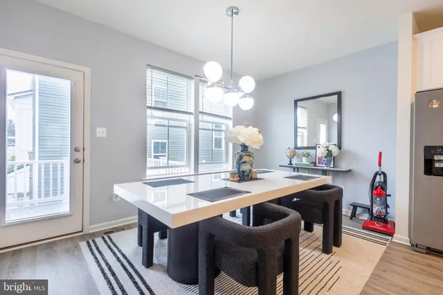 a kitchen with a table chairs and wooden floor