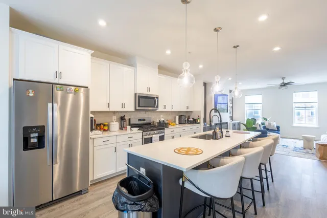 a kitchen with a dining table chairs refrigerator and microwave
