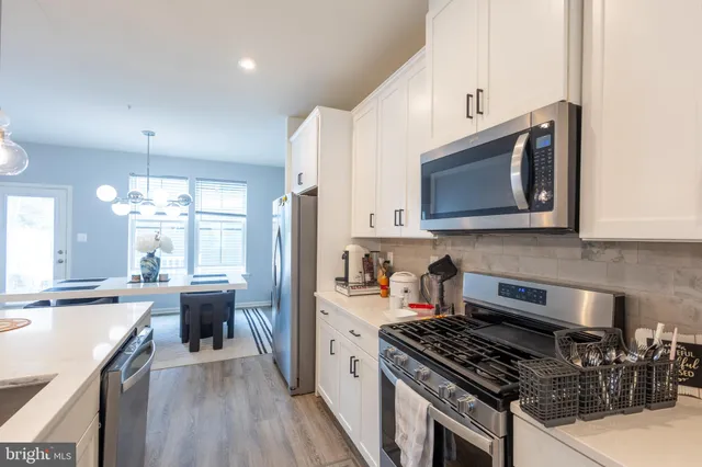 a kitchen with stainless steel appliances a stove sink microwave and cabinets