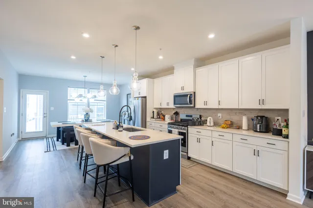 a kitchen with a stove a sink a dining table and chairs