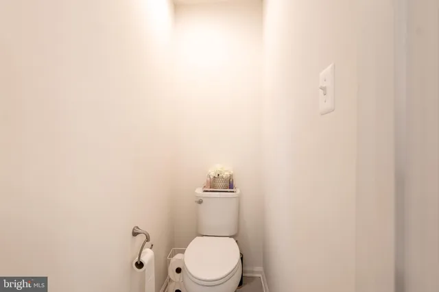 a white toilet sitting next to a white wall