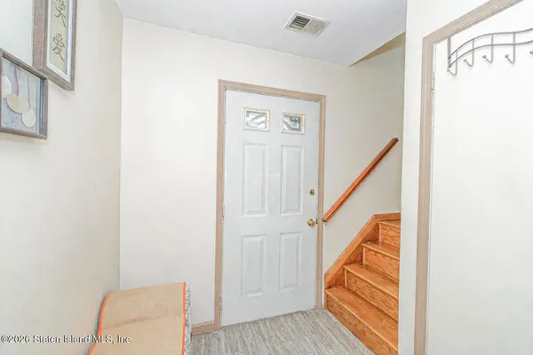 a view of a hallway with wooden floor and entryway