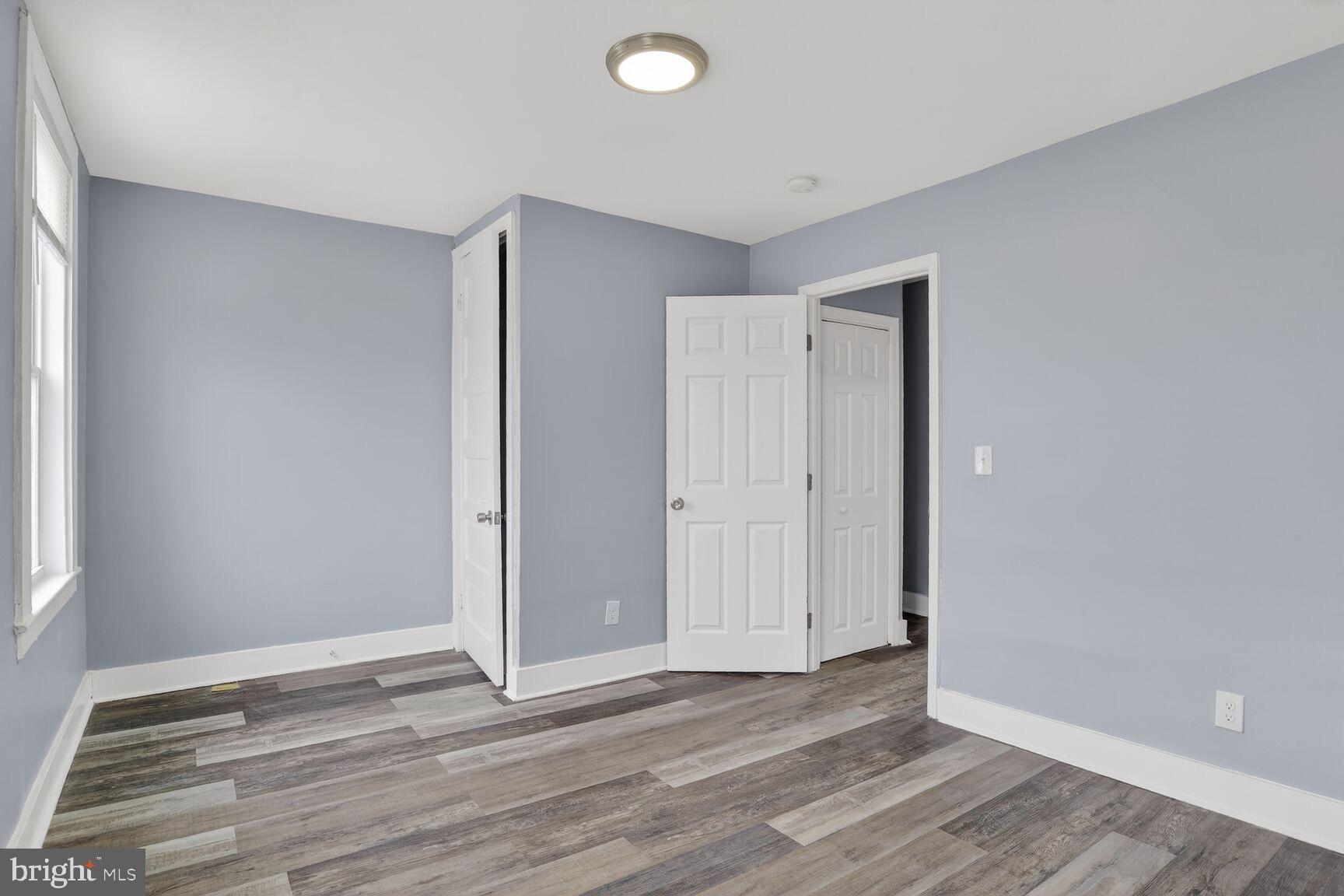 3335 Lyndale Avenue Baltimore, MD 21213 - Photo 4 of 9 a view of an empty room with wooden floor and a window