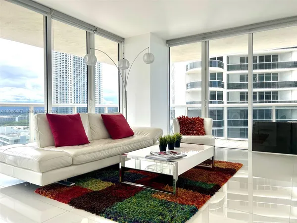 a living room with furniture a table and a large window
