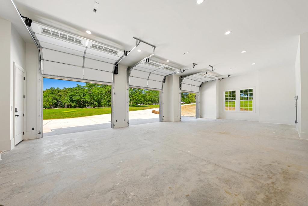 707 Vickery Street Extension Hartwell, GA 30643 - Photo 43 of 50 A spacious, naturally illuminated garage offers ample parking with multiple bay doors and a view of verdant landscaping.