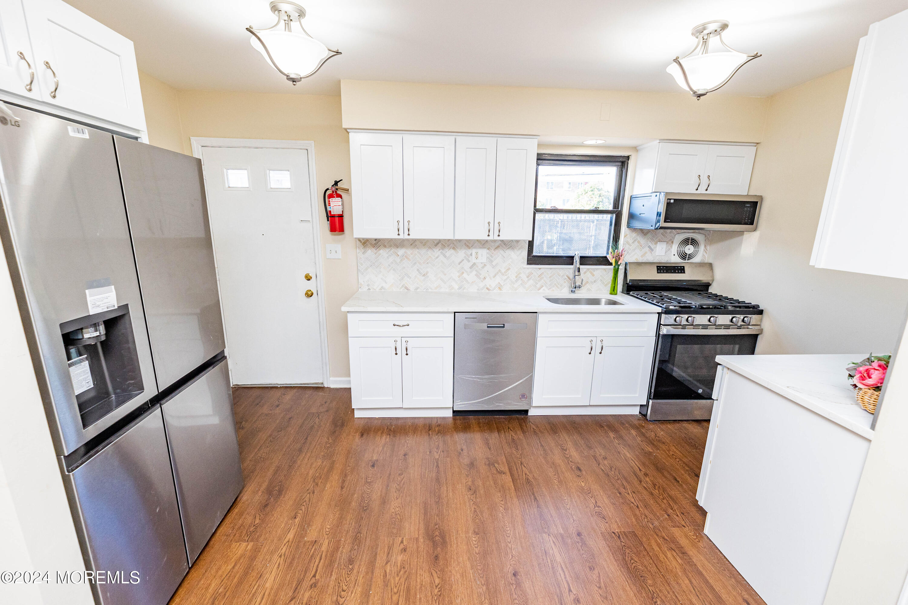 301 Spring Street, Unit 11 Red Bank, NJ 07701 - Photo 1 of 40 a kitchen with granite countertop a refrigerator a sink dishwasher a stove top oven a refrigerator with island and cabinets