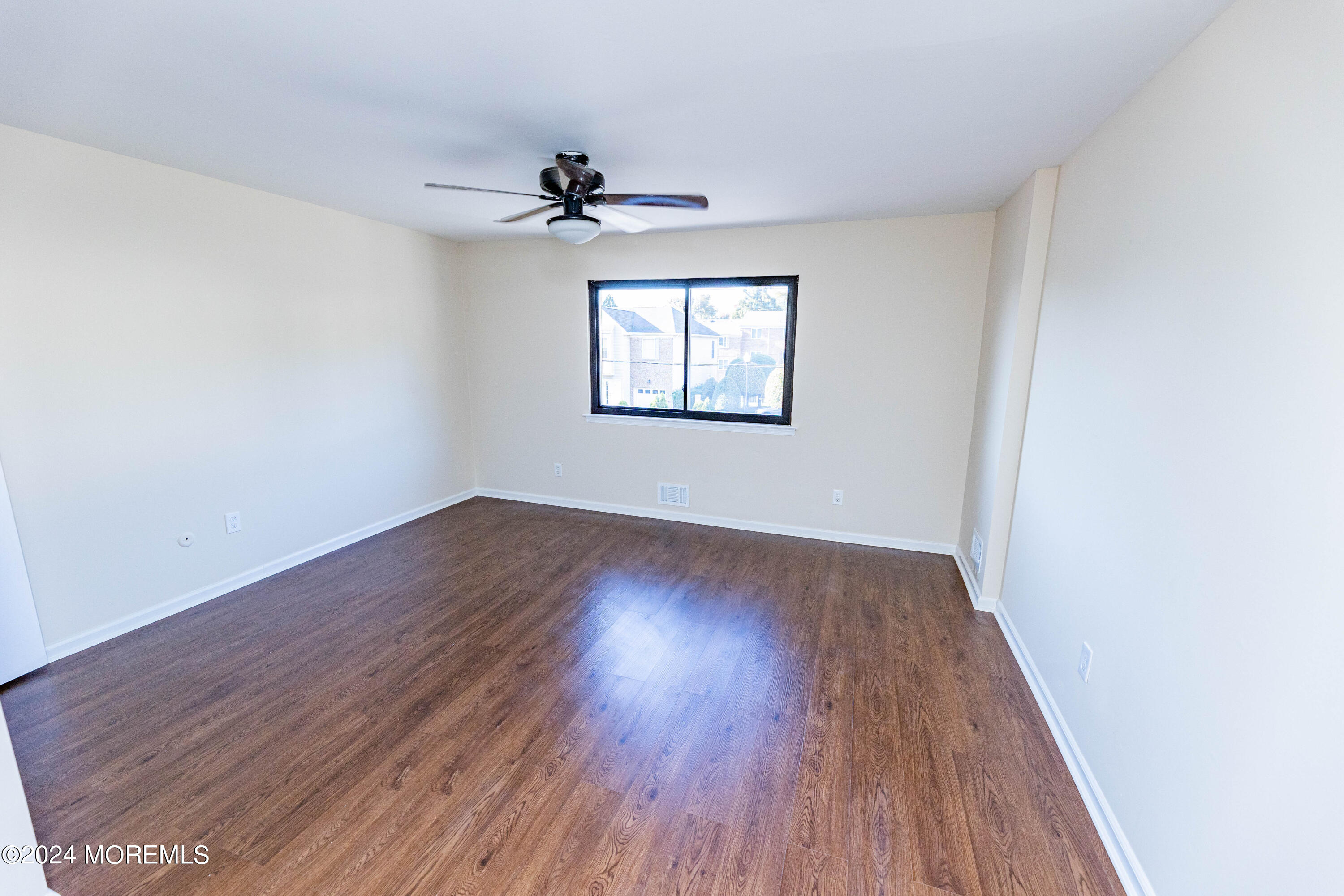 301 Spring Street, Unit 11 Red Bank, NJ 07701 - Photo 20 of 40 a view of an empty room with wooden floor and a window