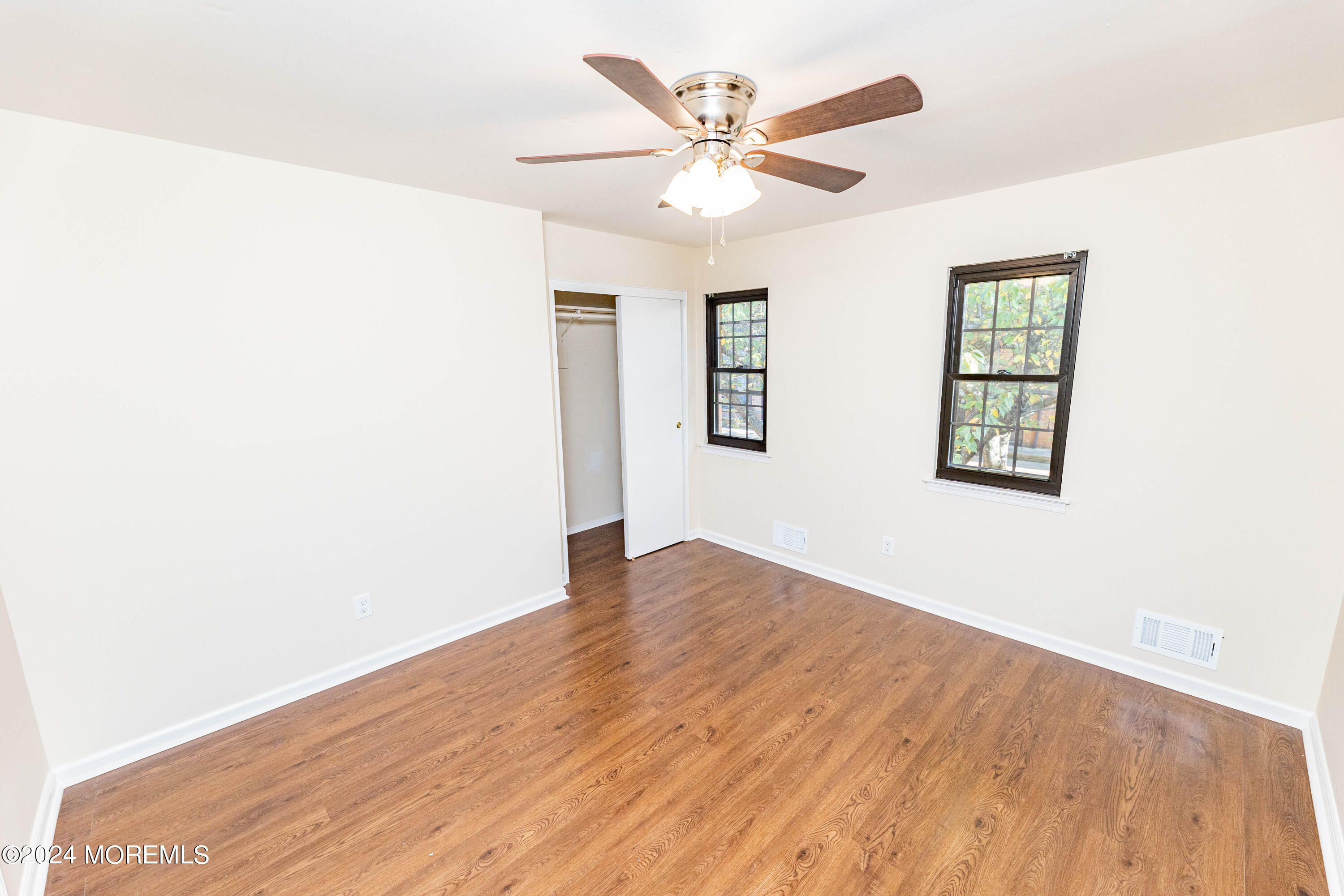 301 Spring Street, Unit 11 Red Bank, NJ 07701 - Photo 22 of 40 an empty room with wooden floor chandelier fan and windows