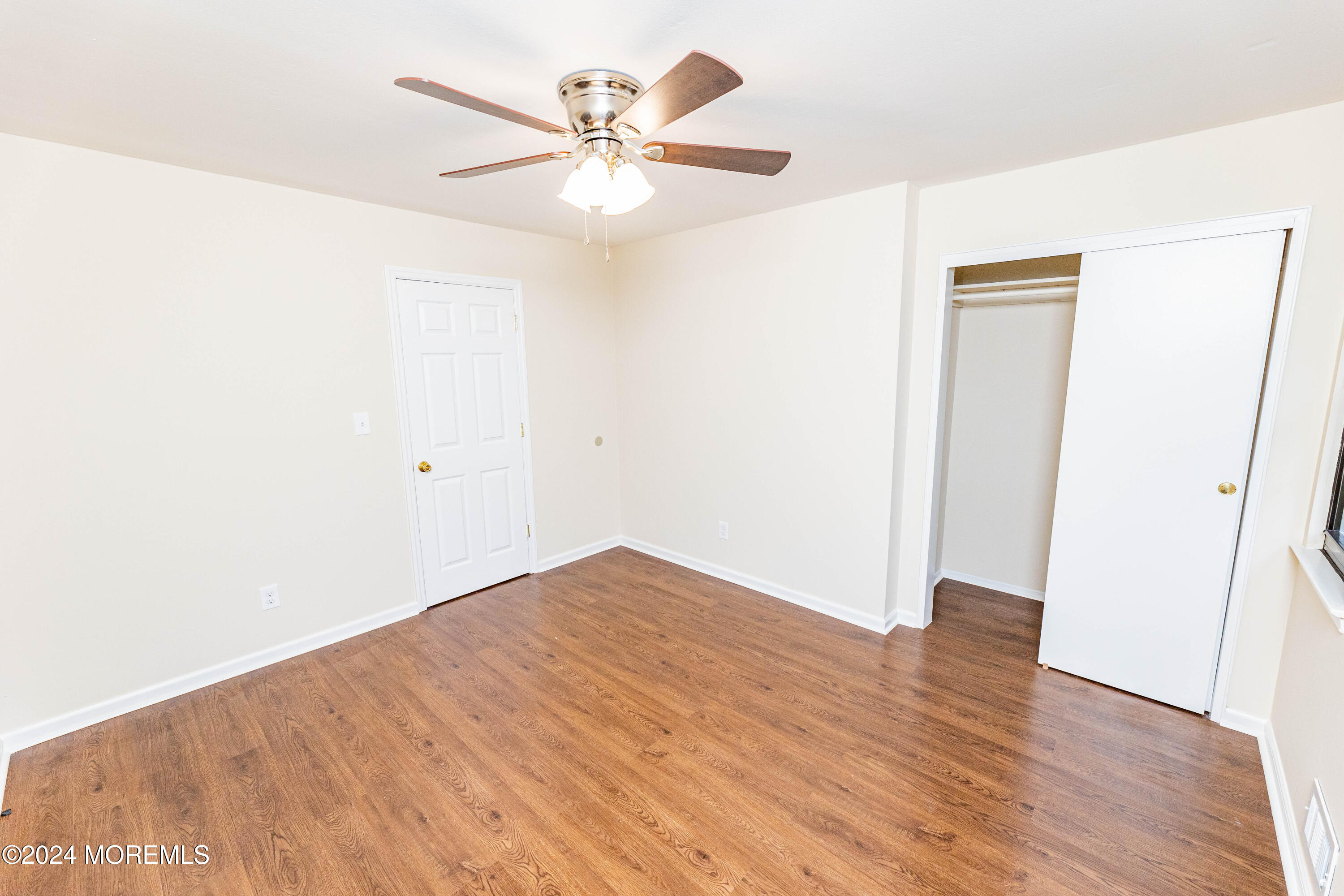 301 Spring Street, Unit 11 Red Bank, NJ 07701 - Photo 27 of 40 an empty room with wooden floor and fan