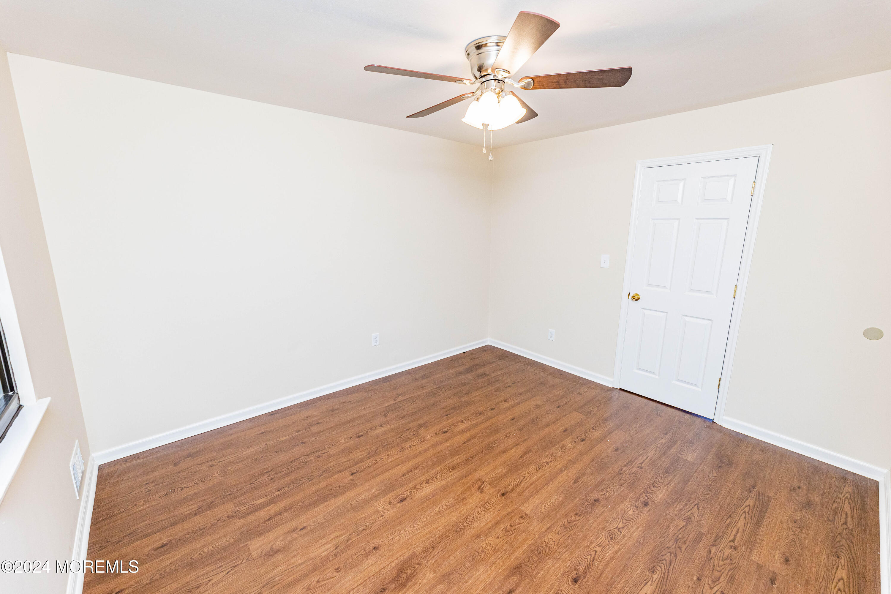 301 Spring Street, Unit 11 Red Bank, NJ 07701 - Photo 28 of 40 an empty room with wooden floor and fan
