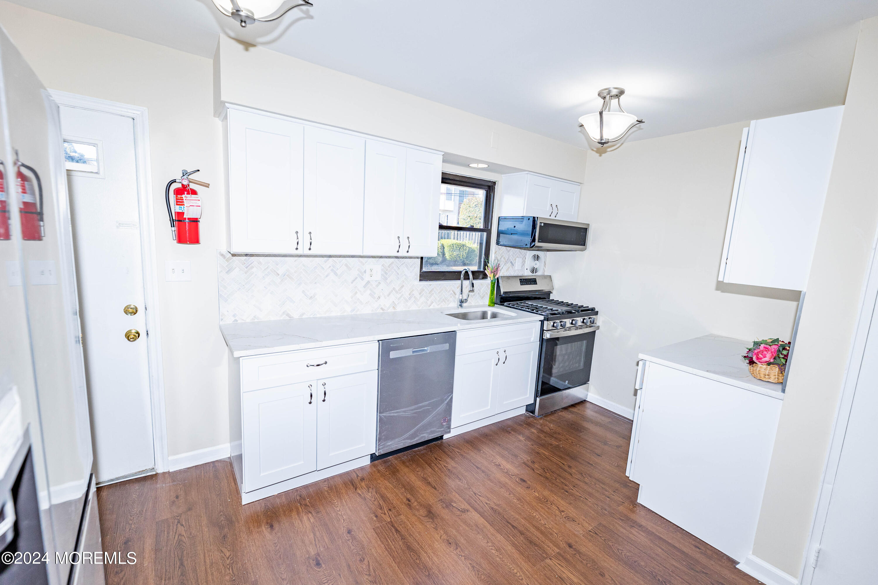 301 Spring Street, Unit 11 Red Bank, NJ 07701 - Photo 6 of 40 a kitchen with a white cabinets stove and refrigerator