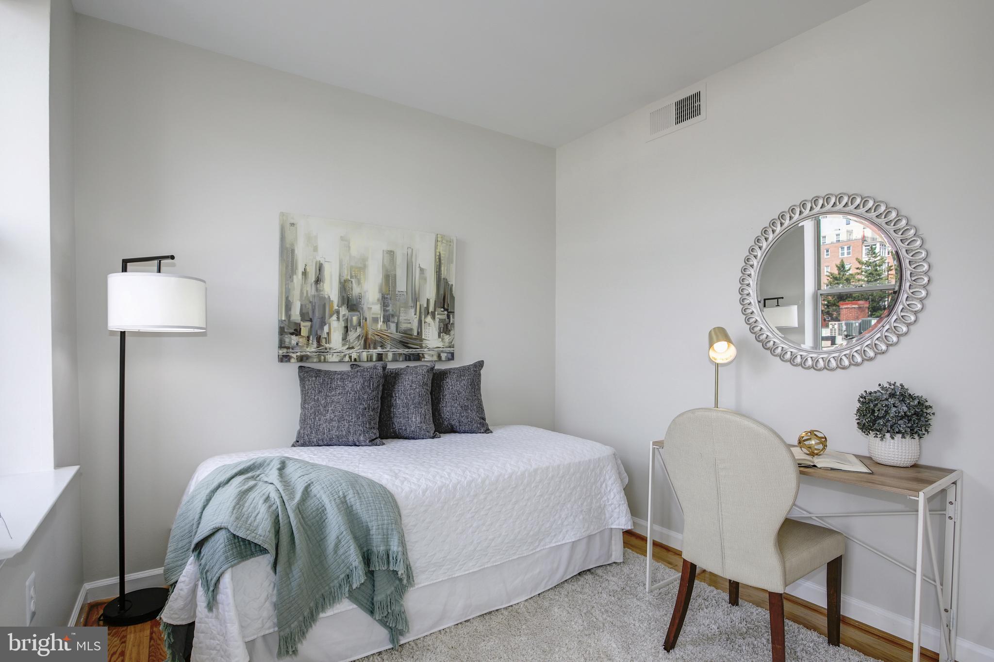 1619 R Street Northwest, Unit 404 Washington, DC 20009 - Photo 10 of 24 a bedroom with a bed a table and chair