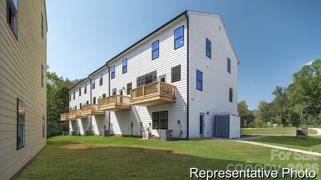 a view of a white building with a yard