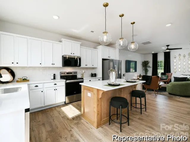 a kitchen with a sink a stove and chairs