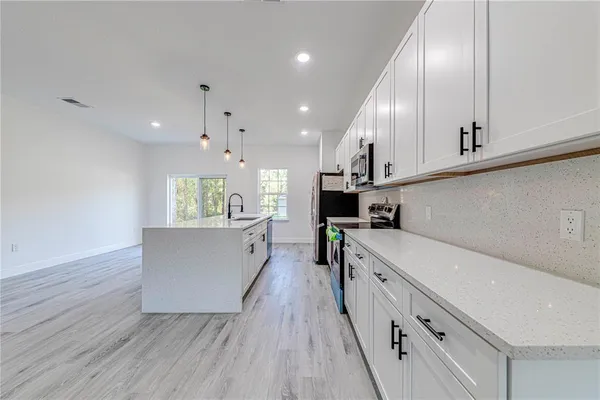 a kitchen with cabinets wooden floor and a sink
