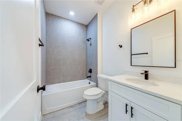a bathroom with a toilet a sink a mirror and bathtub