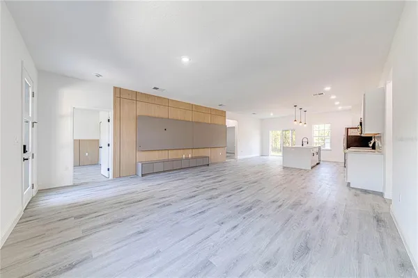 a view of a big room with wooden floor and windows