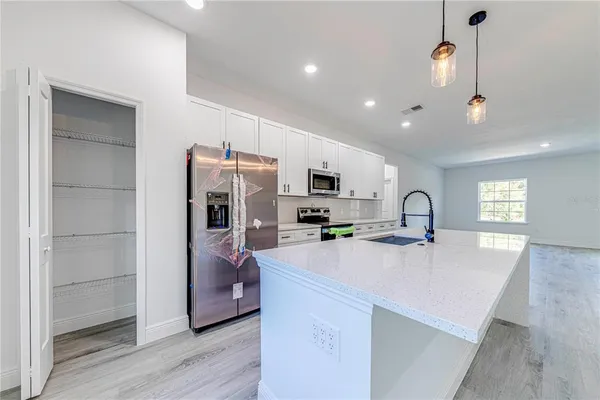 a kitchen with stainless steel appliances a microwave sink refrigerator and microwave