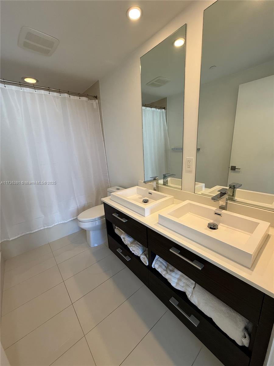 55 Southwest 9th Street, Unit 1701 Miami, FL 33130 - Photo 23 of 58 a bathroom with a double vanity sink and a mirror