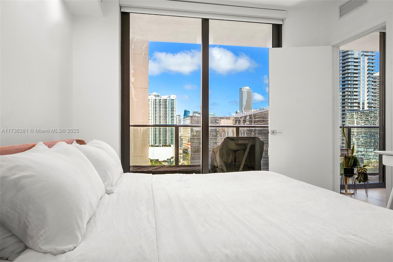 55 Southwest 9th Street, Unit 1701 Miami, FL 33130 - Photo 30 of 58 a bedroom with a large bed and a chandelier