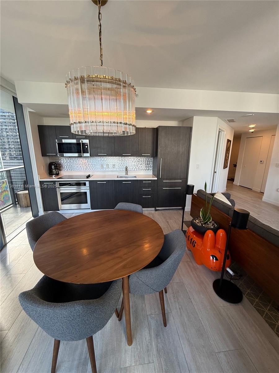 55 Southwest 9th Street, Unit 1701 Miami, FL 33130 - Photo 58 of 58 a kitchen with stainless steel appliances a dining table chairs stove and cabinets