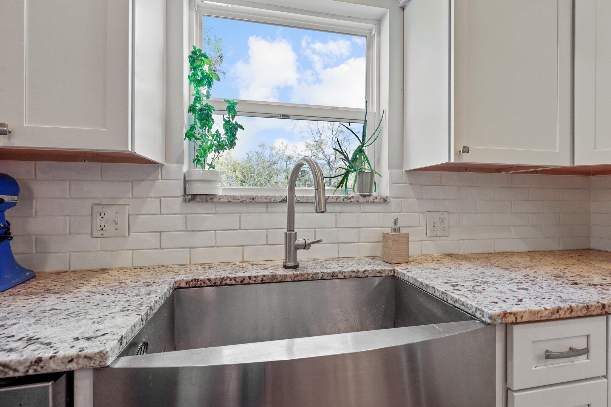 8200 Flint Road Columbus, OH 43235 - Photo 21 of 65 Granite countertops, subway tile backsplash, stainless steel apron front farmhouse sink.