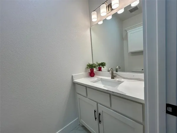 a bathroom with a sink vanity and mirror