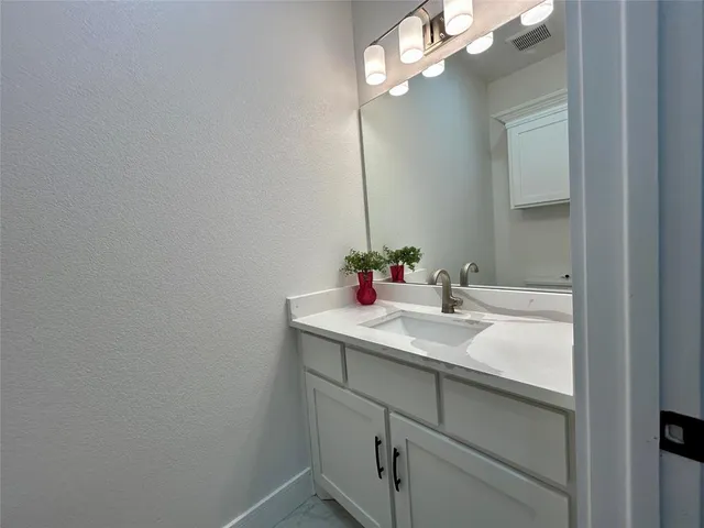 a bathroom with a sink vanity and mirror