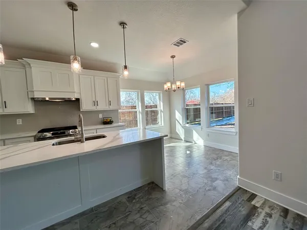 a large kitchen with lots of counter space and wooden floor