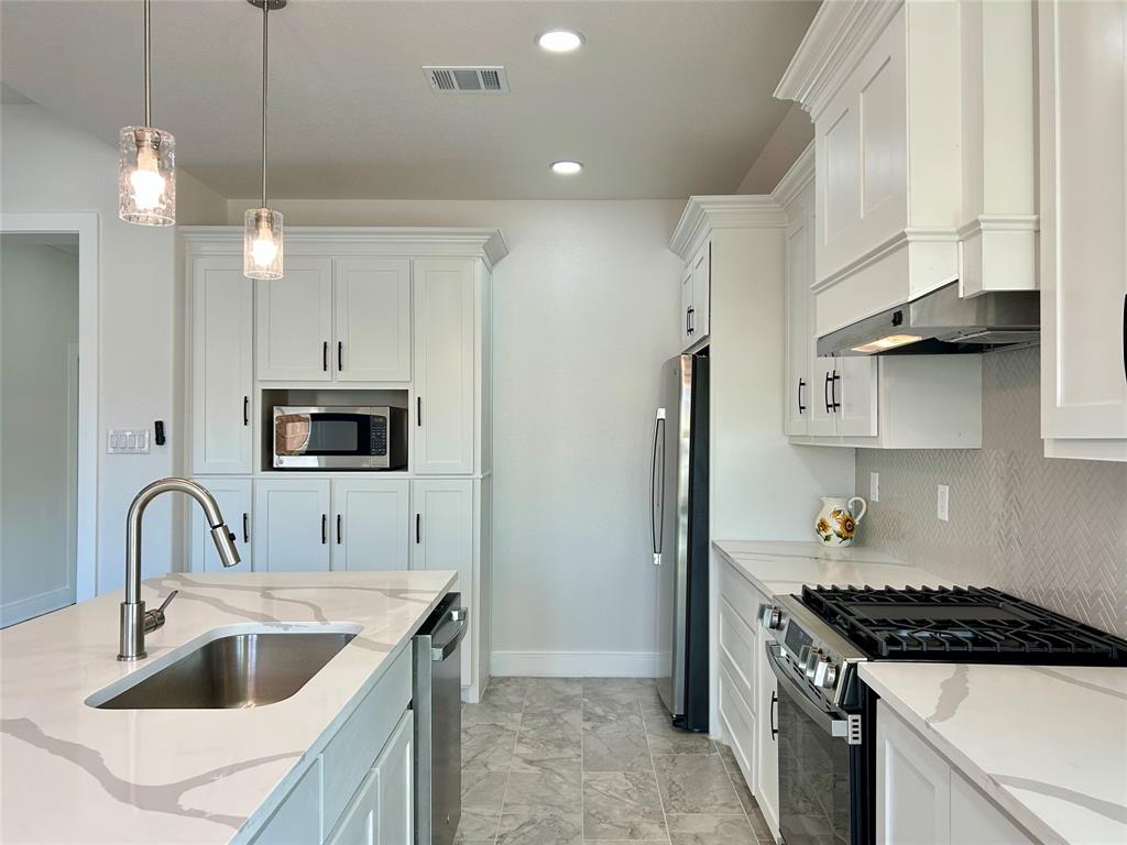 802 South Medora Street Terrell, TX 75160 - Photo 17 of 34 a kitchen with stainless steel appliances granite countertop a sink stove and refrigerator