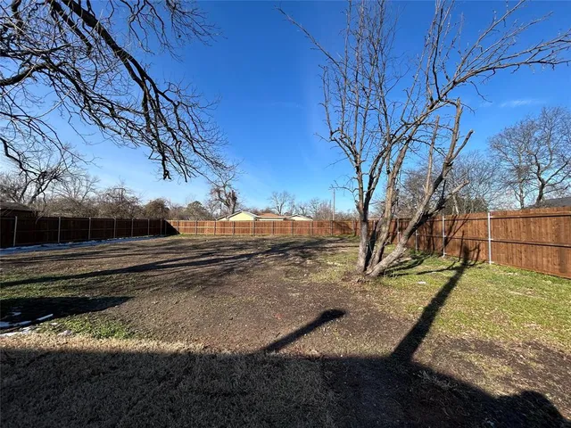 a view of a backyard with wooden fence