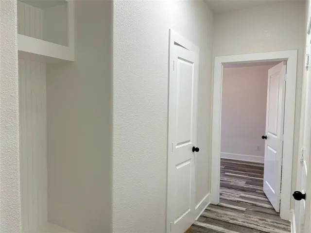 a view of a hallway with wooden floor and closet